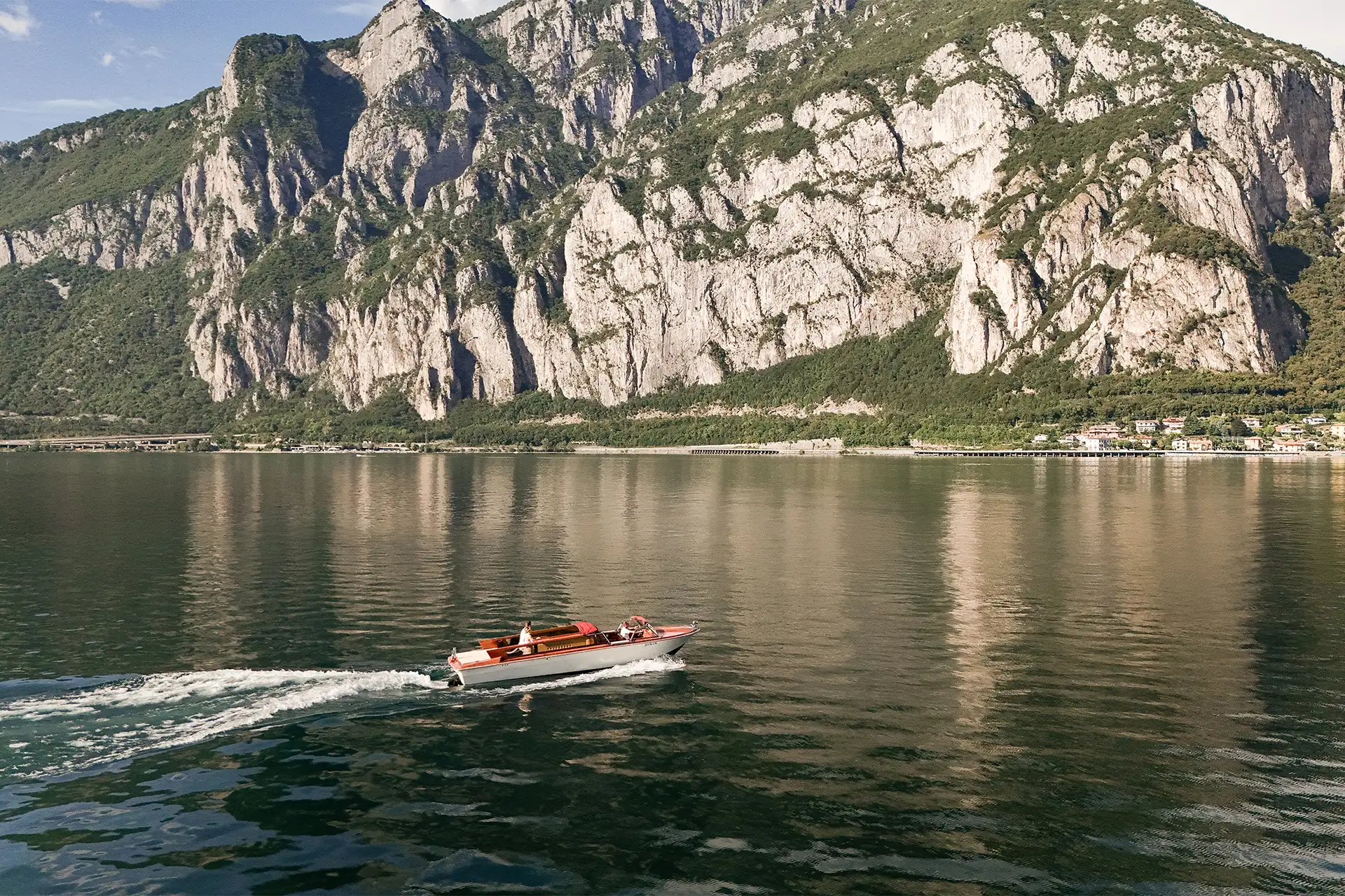 Wooden boat crossing Lake Como after a Villa Giulia wedding