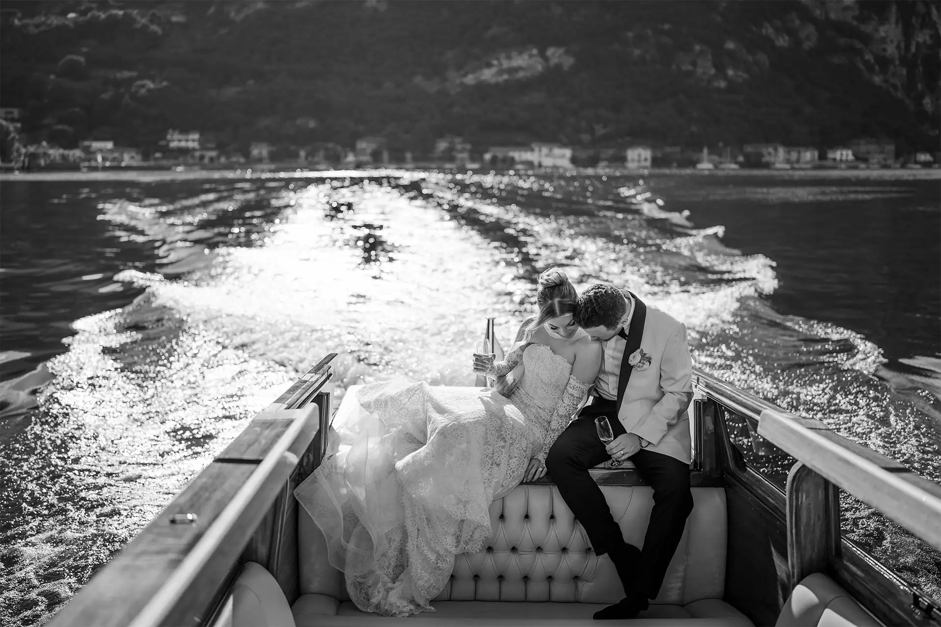 Bride and groom sharing a romantic moment on a wooden boat on Lake Como