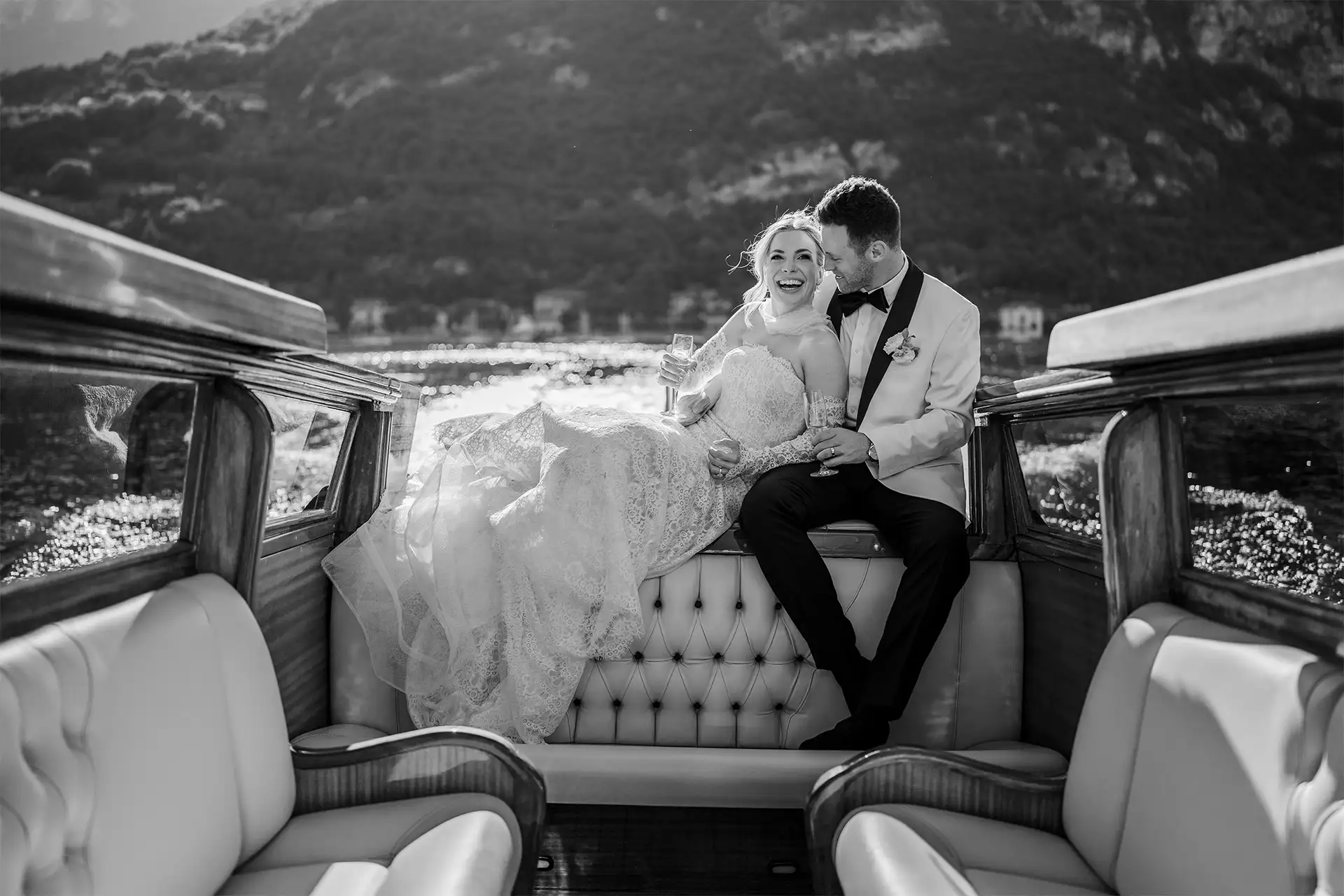 Bride sitting on a wooden boat with Lake Como in the background