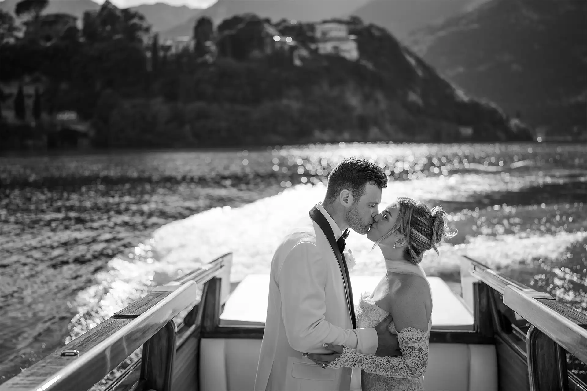 Bride and groom kissing on a wooden boat during a Lake Como wedding