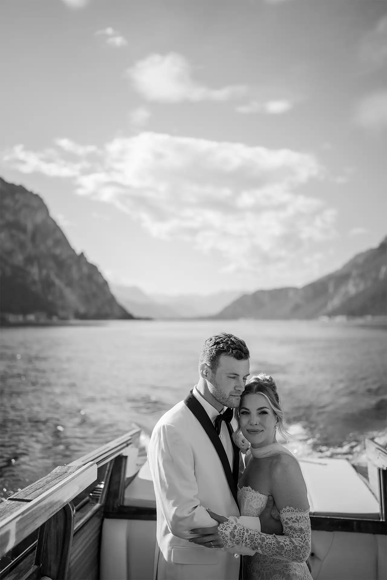 Black and white portrait of bride and groom seated on a boat on Lake Como