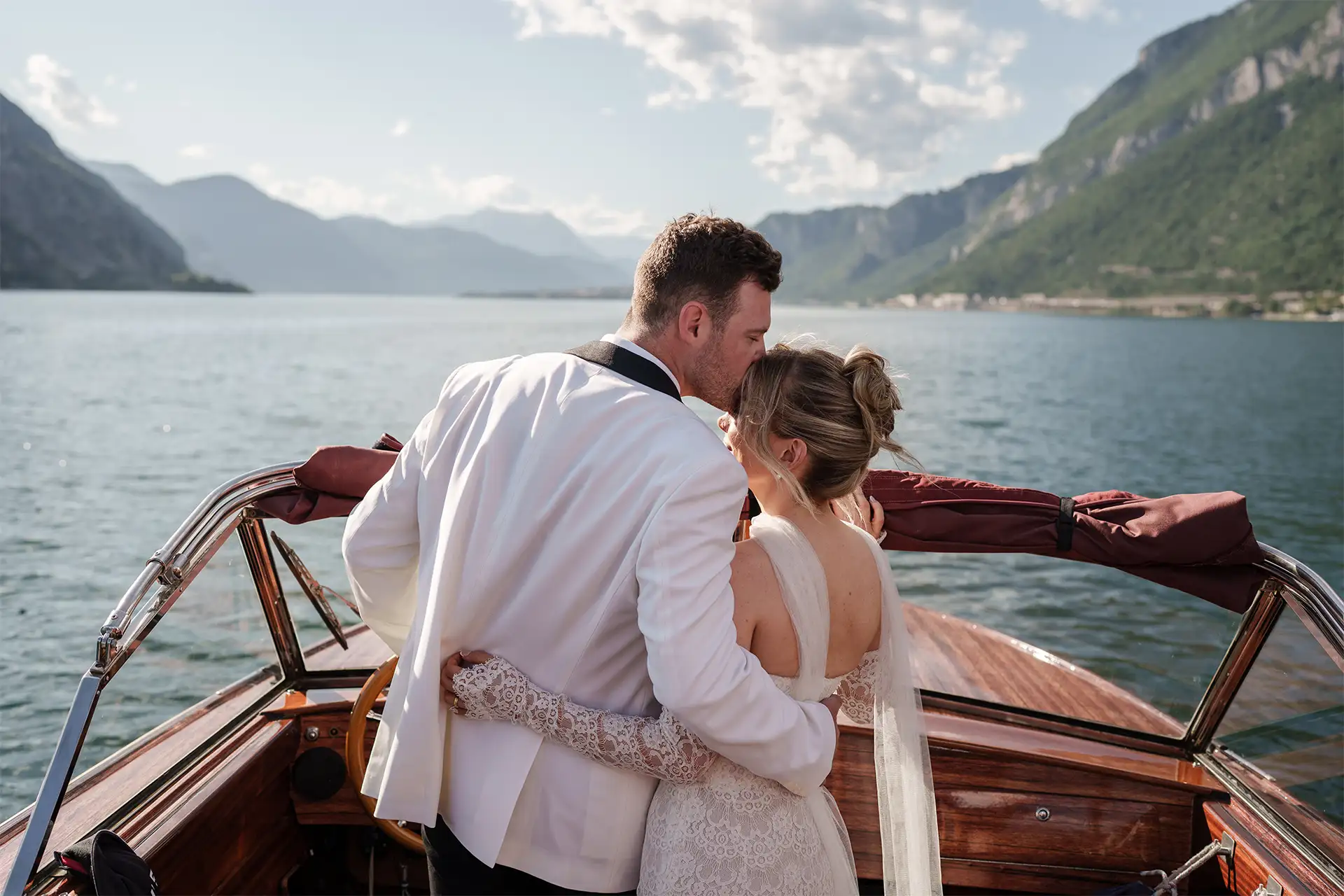 Bride and groom embracing on a wooden boat during a Lake Como wedding