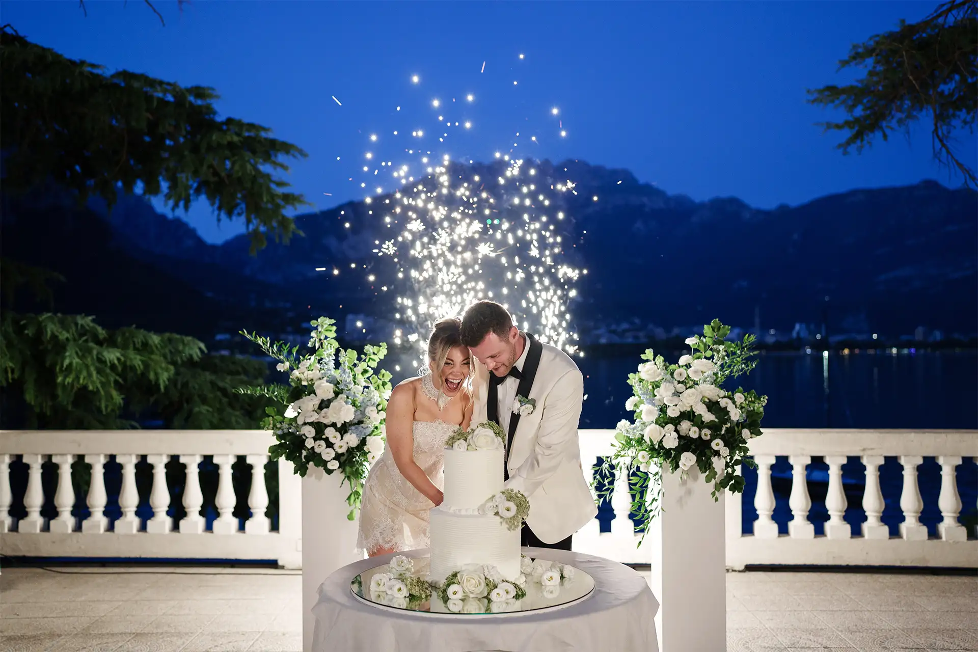 Bride and groom cutting their wedding cake with sparklers at Villa Giulia