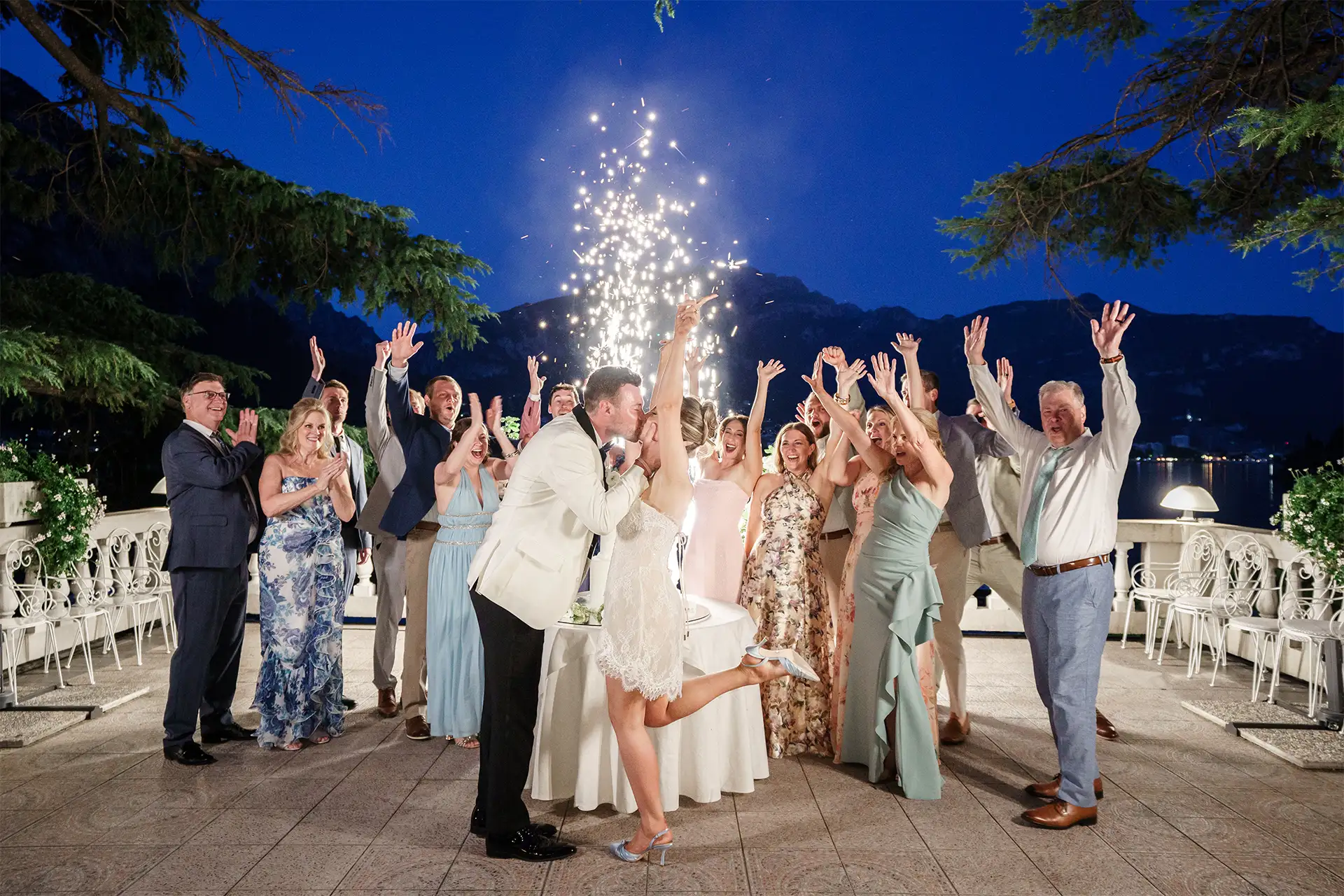 Bride and groom cutting the wedding cake surrounded by guests at Villa Giulia